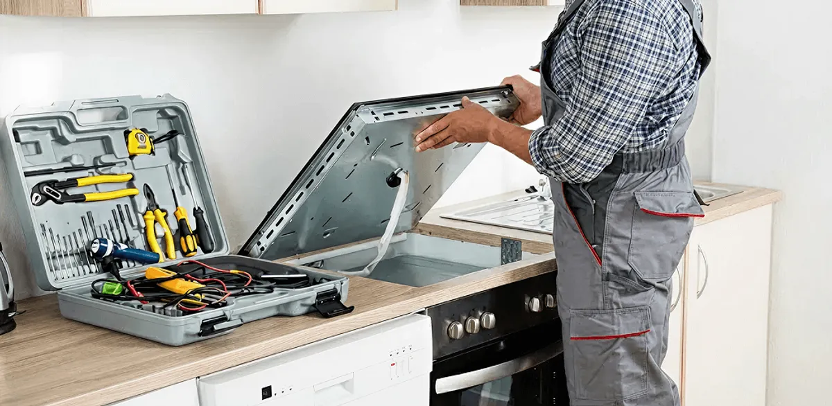 Handyman repairing a cooktop and checking wiring connections in Los Angeles, CA